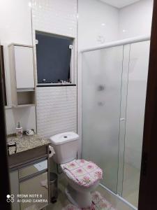 a bathroom with a toilet and a shower at Lindo sobrado a beira rio in Piçarras