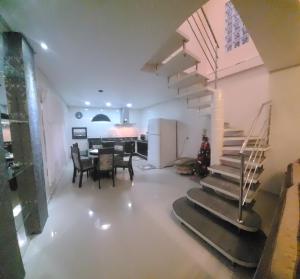 a dining room and kitchen with a staircase in a house at Lindo sobrado a beira rio in Piçarras