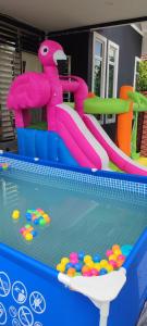 um escorrega aquático numa piscina com bolas em Villa Tamu Dr Din - Pool OR Soopa Doopa em Rantau Panjang