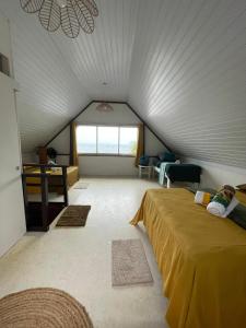 a attic room with a bed and a window at Faré Ahonu beach house in Mahina
