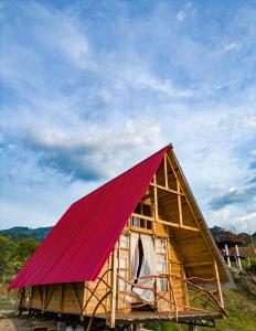 a small wooden house with a red roof at Los Nevados Ecolodge in Gigante
