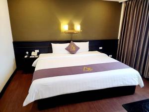 a bedroom with a large bed in a room at Azumaya Hotel Phnom Penh in Phnom Penh