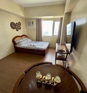 um quarto com uma mesa, uma cama e uma janela em Condo near Ateneo and Royal Mandaya em Davao