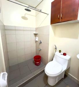 a small bathroom with a toilet and a shower at Condo near Ateneo and Royal Mandaya in Davao City