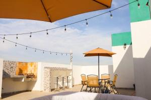 un patio con sillas y una mesa con sombrilla en Exclusivo Pent House en el Corazón de Mty,Jacuzzi! -MTY LH10A-, en Monterrey