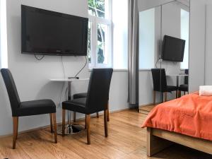 - une chambre avec des chaises et une télévision murale dans l'établissement Relaxing 2-Bed Apartment for Extended Visits, à Vienne