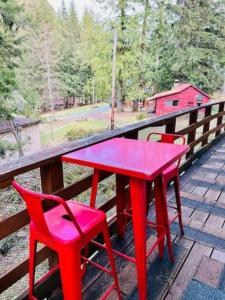 una mesa roja y dos sillas rojas en una terraza en Green Hill at Rainier Lodge (0.4 miles from the entrance) en Ashford