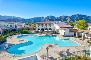 uma piscina num resort com montanhas ao fundo em Gated PGA West 2023 New Build - EV Friendly em La Quinta