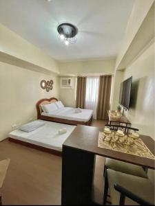 a hotel room with two beds and a table at Condo near Ateneo and Royal Mandaya in Davao City