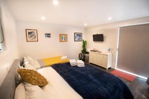 a bedroom with a bed and a television in it at CLASSY CABIN - IN TOWN - SPA POOL in Queenstown