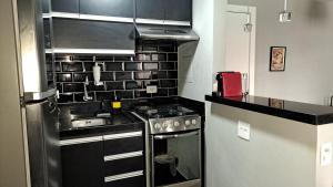 a kitchen with a stove and a counter top at Flat WiFi Ar Piscina Academia Estac Itaim Bibi in Sao Paulo