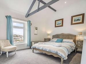 a bedroom with a bed and a chair and a window at 3 bed property in Brixham 88018 in Brixham