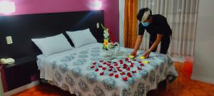 una mujer haciendo una cama con un montón de pastelitos en HOTEL CASA REAL, en Tacna