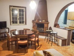 ein Wohnzimmer mit einem Tisch, Stühlen und einem Kamin in der Unterkunft Natural House in Briatico
