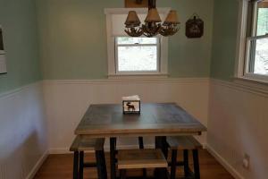 a wooden table in a room with a window and a table with benches at Mohican area secluded 2 bedroom cabin in Loudonville