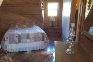 a bedroom with a bed in a log cabin at Mohican area secluded 2 bedroom cabin in Loudonville