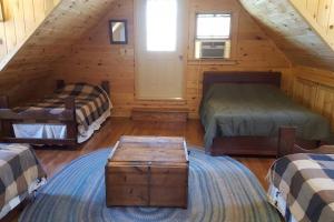 a attic room with two beds and a table at Mohican area secluded 2 bedroom cabin in Loudonville