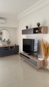 sala de estar con TV de pantalla plana en Studio meublé en Dakar