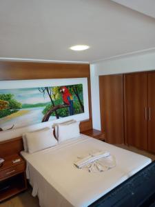 a bedroom with a bed with a painting on the wall at Mirador Vista Mar 110 in Natal