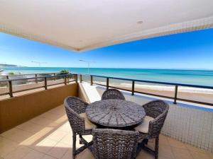 a table and chairs on a balcony with a view of the ocean at Mirador Vista Mar 110 in Natal