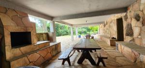 a living room with a table and a stone wall at Fazenda Araras Eco Turismo - Acesso ilimitado a Cachoeira Araras in Pirenópolis