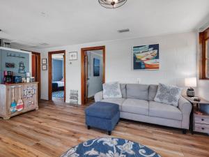 a living room with a couch and a blue stool at Waterfront on Lake Talquin - Near FSU - Stunning Views - 2 Story Deck - Fire Pit - Fast 1000 mbps Internet - 3 min from Boat Ramp in Tallahassee