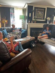 a group of people sitting in a living room at The Connecticut River Valley Inn Hartford South/Glastonbury in Glastonbury