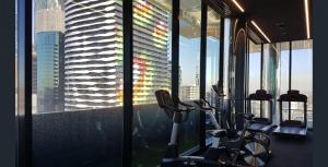 een fitnessruimte met uitzicht op een wolkenkrabber bij Lovely & Quiet 2-Bed in the Heart of Carlton in Melbourne
