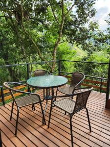 une table et des chaises sur une terrasse en bois dans l'établissement Ecomariposa, à La Vega