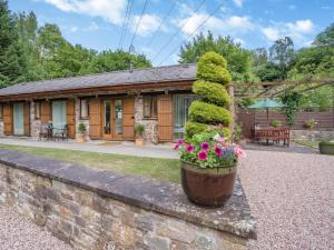 a cottage with flowers on a stone wall at 2 Bed in Abergavenny BN187 in Clydach