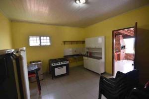 - une cuisine avec des murs jaunes et une cuisinière dans l'établissement Recanto Minas a Goiás, à Ceres