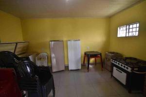 - une cuisine avec 2 réfrigérateurs, une table et une fenêtre dans l'établissement Recanto Minas a Goiás, à Ceres