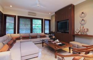 a living room with a couch and a tv at Villa Ocean in Tanah Lot