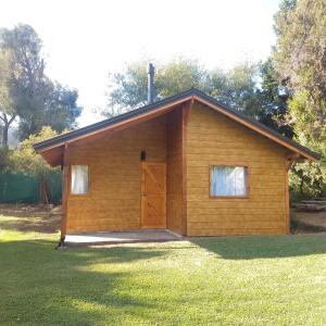 Vertientes de Lolog في جونين دي لوس أنديس: مبنى خشبي صغير مع باب في العشب
