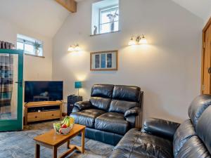uma sala de estar com um sofá de couro e uma mesa em 2 Bed in Hartington PK763 em Hartington