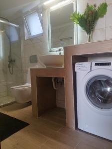 a bathroom with a washer and a sink and a washing machine at Giannis House 2 minutes walk to the beach Peroulia in Kómboi