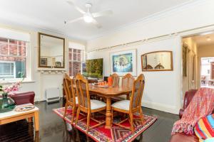 una sala da pranzo con tavolo e sedie di Eclectic Art Deco Apartment in great location a Sydney