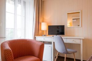 una camera d'albergo con sedia e televisore di Hotel Maxant a Frymburk
