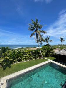 a swimming pool with a view of the ocean at Villa Ocean in Tanah Lot