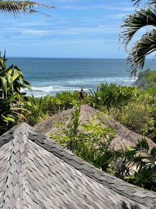 a person standing on a hill near the ocean at Villa Ocean in Tanah Lot
