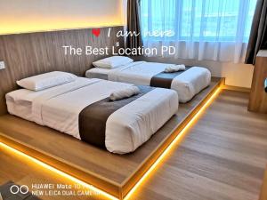 波德申THE BEST LOCATION的地板上带灯的房间的两张床