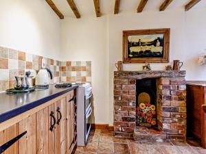 a kitchen with a brick fireplace in a room at 1 Bed in Ironbridge 80587 in Leighton