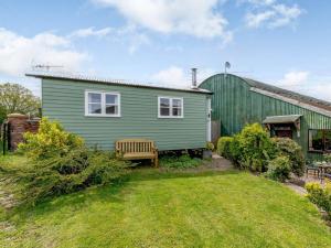 a green house with a bench in the yard at 1 Bed in Ironbridge 80587 in Leighton