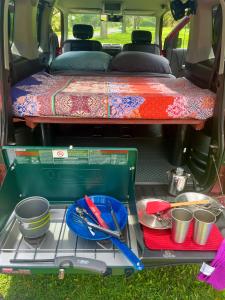 an open trunk of a van with plates and utensils at Go Camp Maui-Exploring Maui in a Campervan in Ah Fong Village