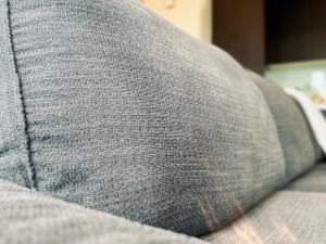 a close up of a gray pillow on a couch at Cozy Tamarind Suites in Cyberjaya