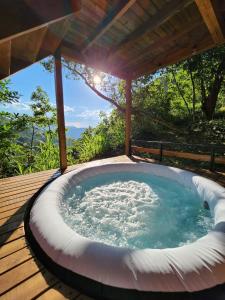 una bañera de hidromasaje en una terraza de madera en Ecomariposa, en La Vega