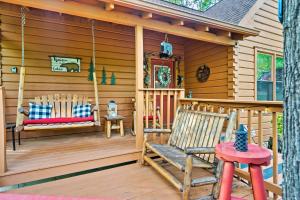 a cabin with two rocking chairs on a porch at New! Cozy, ADA Accessible, Family Cabin w/ Hot Tub in Sevierville