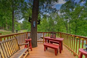a wooden deck with benches and a table and a tree at New! Cozy, ADA Accessible, Family Cabin w/ Hot Tub in Sevierville