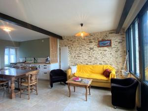 a living room with a yellow couch and a table at Maison Sarzeau, 3 pièces, 4 personnes - FR-1-639-106 in Sarzeau