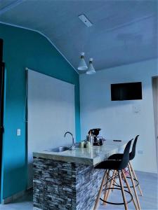- une cuisine avec un évier et un mur bleu dans l'établissement Reserva La Esperanza, à Vergara